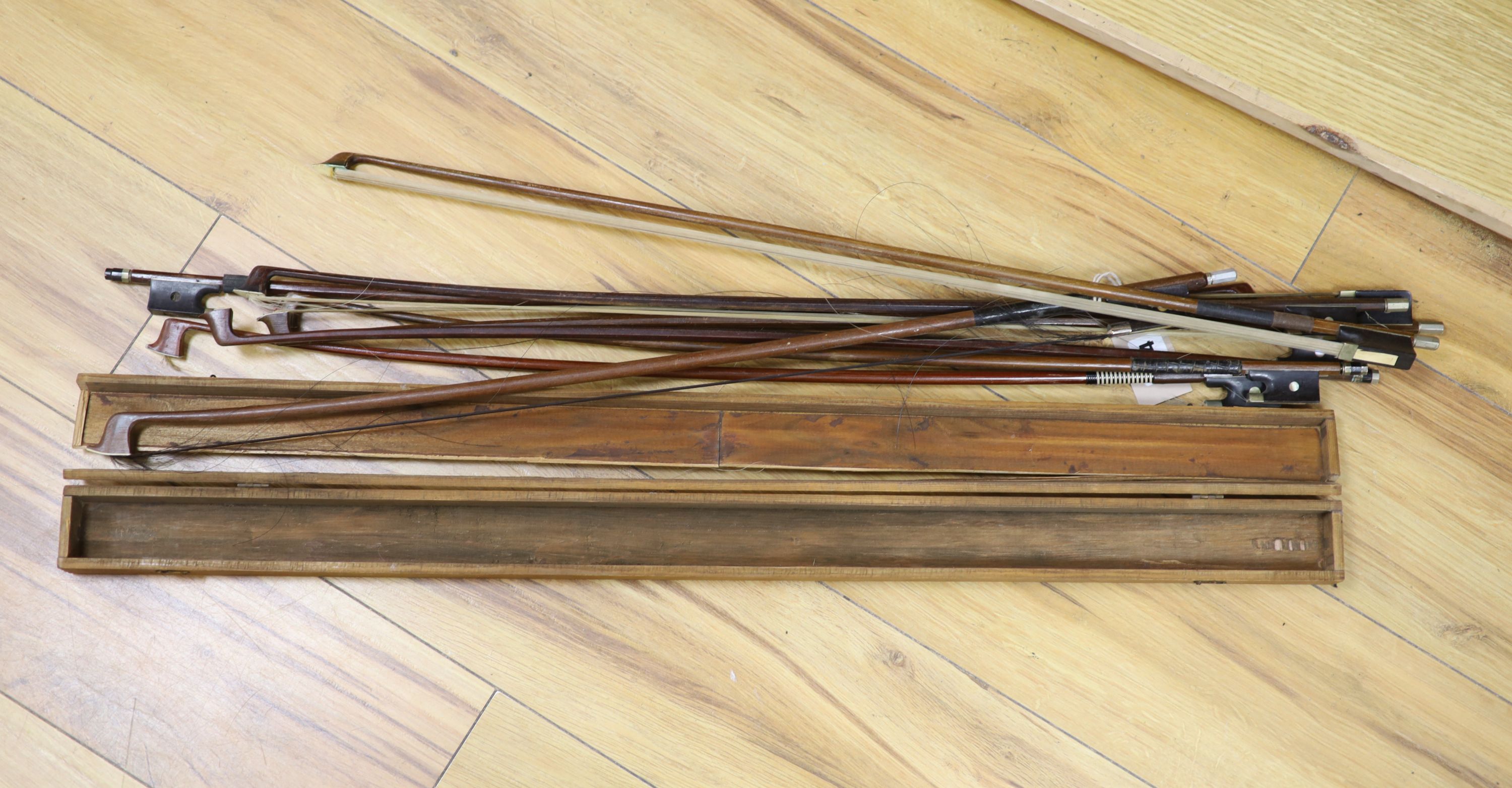 A quantity of violin bows and box, together with a print